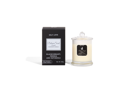 Body Safe, Organic Massage Candle in Self Love Scent, which is Blackcurrant , Fressia and Patchouli fragrance Silver Highlights on a black box next to the glass massage candle.