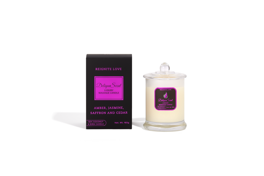 Body Safe, Organic Massage Candle in Reignite Love Scent, which is Amber, Jasmine, Saffron and Cedar  fragrance Bright Pink Highlights on a black box next to the glass massage candle.