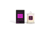 Body Safe, Organic Massage Candle in Reignite Love Scent, which is Amber, Jasmine, Saffron and Cedar  fragrance Bright Pink Highlights on a black box next to the glass massage candle.
